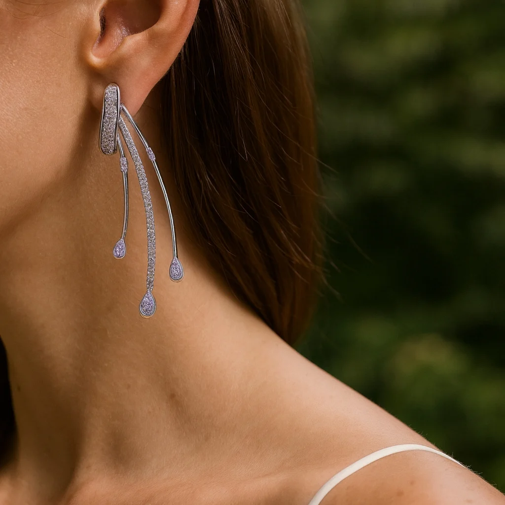 Close-up of a model wearing silver waterfall-style tassel earrings encrusted with small diamonds and light purple teardrop stones.